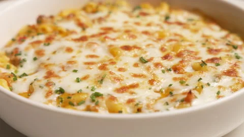 Cheesy macaroni pasta with ground meat and herbs slowly rotating in a white bowl 動画素材 339153103