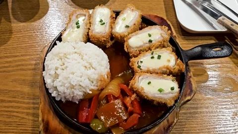 Cheesy pork cutlets served with white rice and stir-fried vegetables in savory 動画素材 316735894