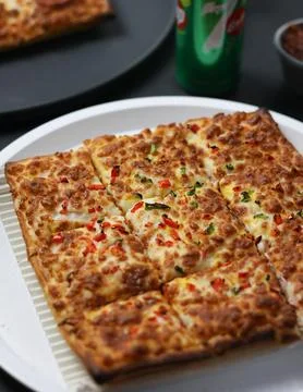 Cheesy rectangular pizza with colorful vegetable toppings Stock Photos