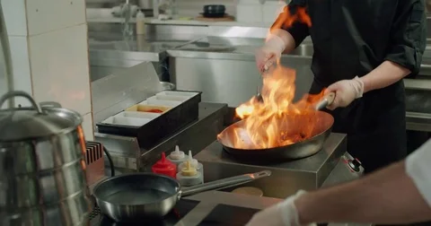 Chef actively working in the kitchen of the restaurant with Asian cuisine Stock Footage 77299733