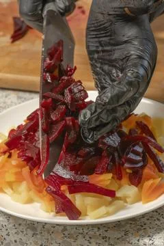 Chef adding boiled beetroot to boiled potatoes and boiled carrots to make v.. Stock Photos