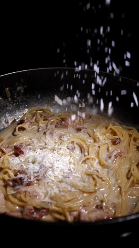 Chef adding carbonara pasta with grated cheese in a frying pan. restaurant Stock Footage 309196742