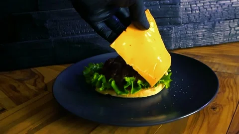 Chef Adding Cheese to a Hamburger in Slow Motion Stock Footage 335130934
