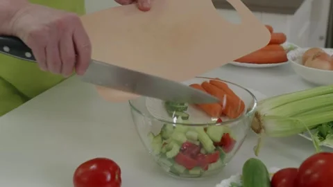 Chef adding chopped celery to fresh vegetable salad Stock Footage 321041764