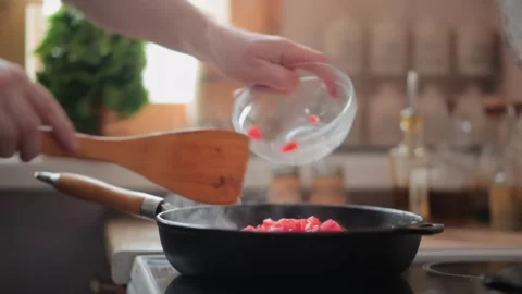 Chef adding chopped tomatoes to a hot steaming skillet Stock Footage 312795488