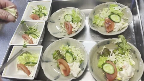 Chef Adding Cucumber And Finishing Fresh Salad Plates In A Japanese Kitchen Stock-Footage 338320355