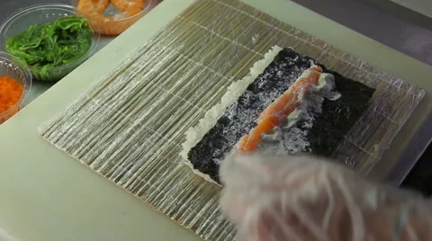 Chef adding cucumber and seaweed to sushi rolls Stock Footage 41947608