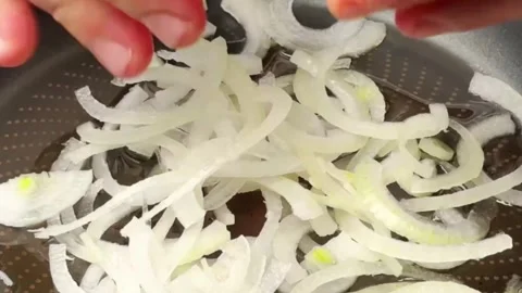 Chef adding fresh oyster mushrooms to sliced onions in a frying pan for cooking Stock Footage 325032323