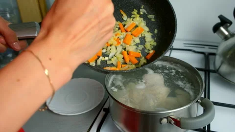 Chef adding fried onions carrots into boiling broth with chicken cooking soup. Video stock 312451107