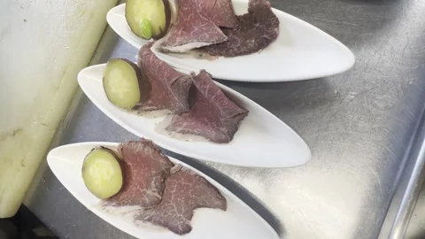 Chef Adding Garnish To Plates Of Sliced Roast Beef Appetizers In Kitchen Stock-Footage 338204034