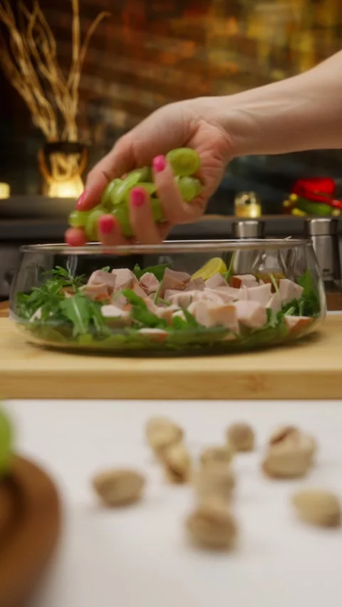 Chef adding grapes to fresh healthy salad with chicken and arugula Stock Footage 310928572