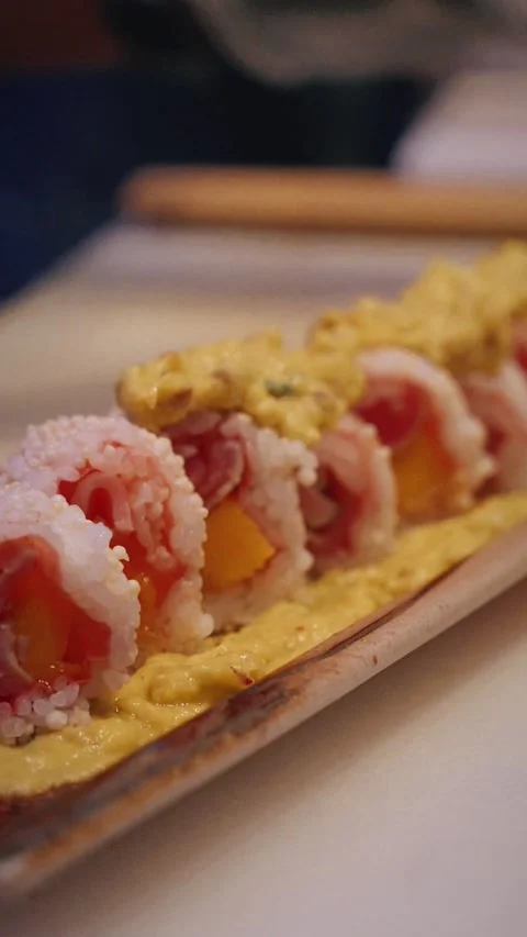 Chef adding guacamole on tuna mango sushi rolls – 4K vertical close up Stock Footage 315509448