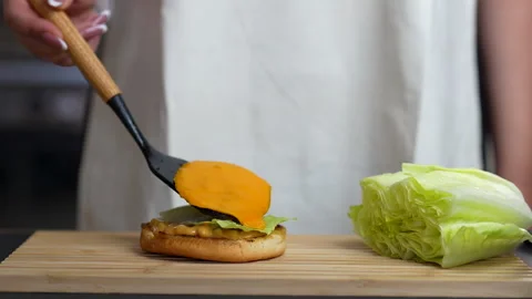 Chef Adding Melted Cheese Slice on Gourmet Burger – HD Close-Up Stock Footage 315303453