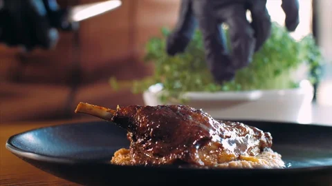 Chef adding a microgreens on roasted duck at restaurant Stock Footage 121467230