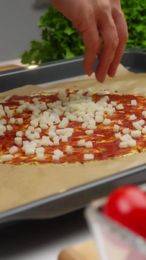 Chef adding mozzarella cheese to pizza dough with tomato sauce Stock Footage 310951483