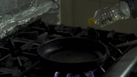 Chef adding oil to the pan, slow motion Stock Footage 73514063