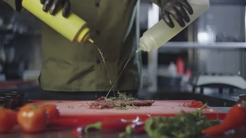 Chef adding oil to steak marinade in kitchen. Stock Footage 232618026