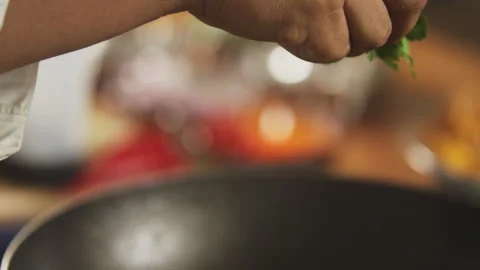 Chef adding parsley to hot pan Stock Footage 274670162