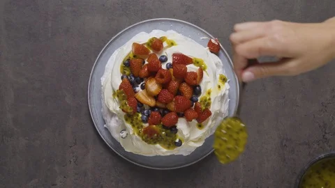 Chef adding passionfruit to a pavlova dessert 스톡 동영상 124584350