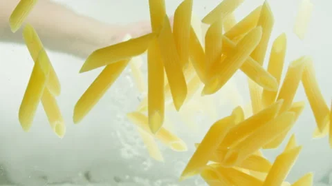 Chef adding penne pasta into boiling water in pot. Cooking Italian pasta in Video stock 238468607
