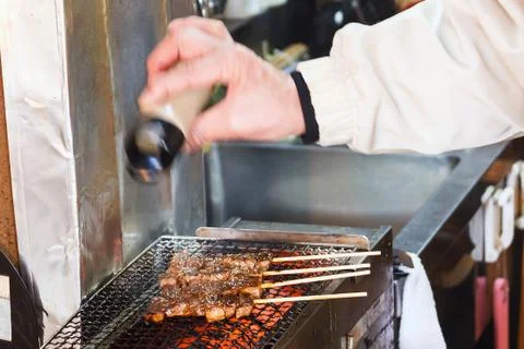 Chef adding pepper to bbq. Stock Photos