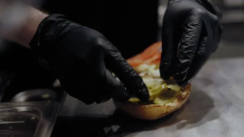 Chef Adding Pickles and Veggies to Burger Buns 스톡 동영상 307083960