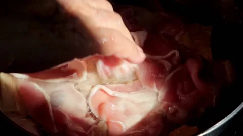 Chef adding raw pork to Homemade Sukiyaki or Shabu boiling in pot  Stock Footage 159004265