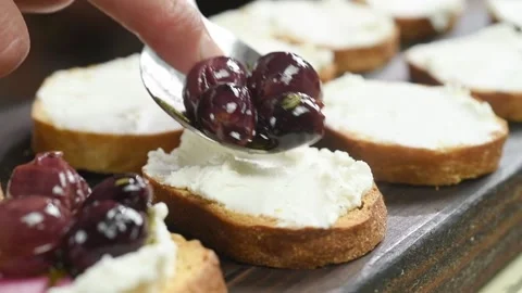 Chef adding roasted grapes on the bruschetta. Stock Footage 202176816