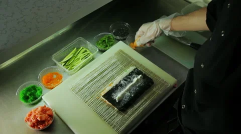 Chef adding salmon and cucumber to sushi rolls 스톡 동영상 41969352