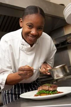 Chef Adding Sauce To Dish In Restaurant Kitchen Stock Photos