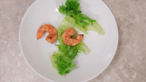 Chef adding shrimps to a salad on a white plate Stock Footage 306904654