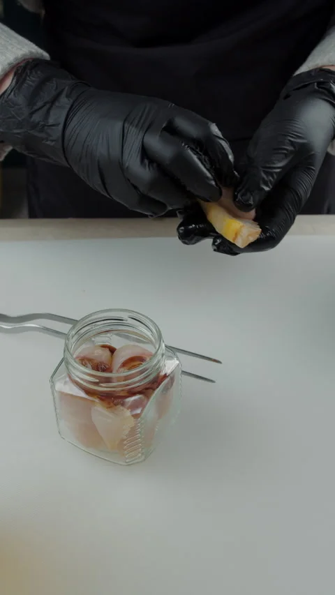 Chef adding smoked fish slice to glass jar Stock Footage 308353864