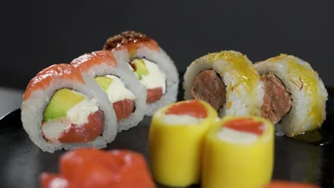 Chef adding soy sauce to salmon avocado sushi roll close up Stock Footage 340143498