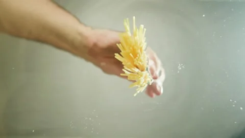 Chef adding spaghetti Italian penne pasta into boiling water in pot. Cooking Stock Footage 238468671