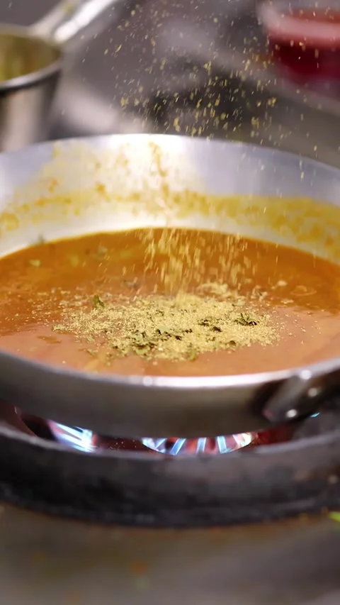Chef Adding Spices to Simmering Curry Sauce in Professional Kitchen Stock Footage 340305416