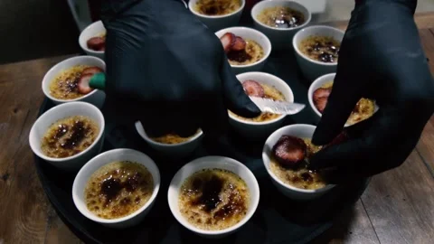 Chef adding strawberry to the creme brulee before to be served Stock Footage 143685617