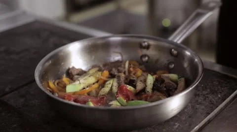 Chef adding tomato sauce in frying pan with vegetables and meat and mixing their Stock Footage 68851290