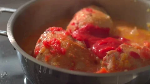 A chef adding tomato sauce to simmer Chicken Cacciatore (Italian chicken stew) Stock Footage 318850621