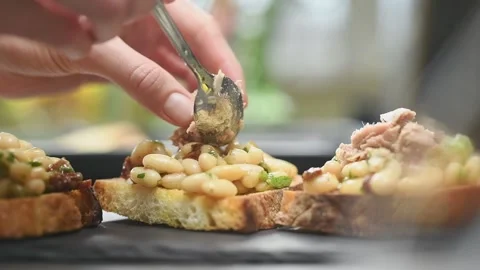 Chef adding tuna on a bruschetta with beans. Stock Footage 161014726