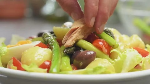 Chef adding tuna on a salad Nicoise with asparagus. Stock Footage 165618091