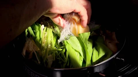 Chef adding vegetable to Homemade Sukiyaki or Shabu boiling in pot Video stock 159004269
