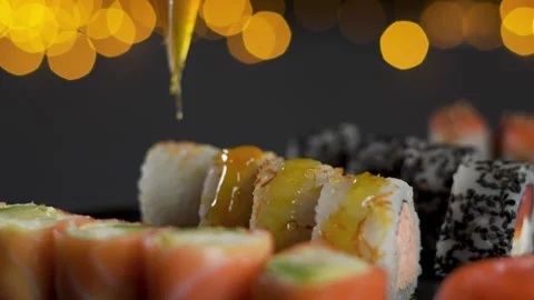 Chef adding yellow sauce to fresh sushi roll macro detail Stock Footage 340546220