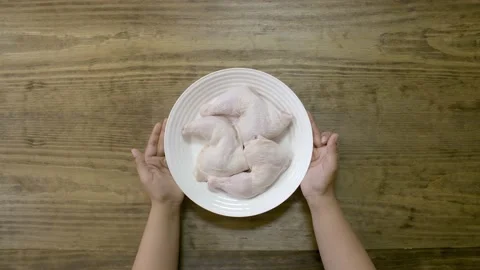 A chef adds and mixes different spices with raw chicken legs Stock Footage 135411612