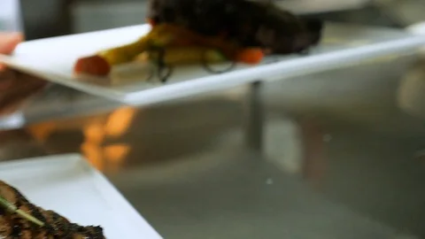 Chef adds another steak plate to shelf slow motion Stock Footage 94262340