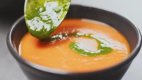 Chef adds basil olive oil on a tasty creamy tomato soup. Stock Footage 153485181