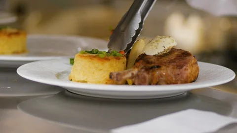 Chef adds boiled vegetables to the plate with chicken and pudding Stock Footage 107342592