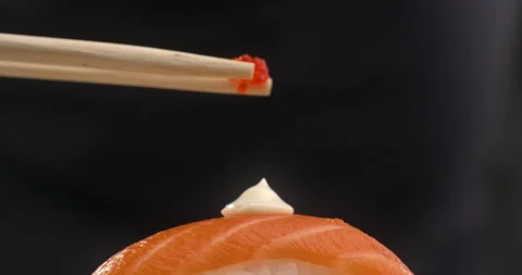 Chef adds caviar to the sushi roll with salmon and rice Video stock 143592926