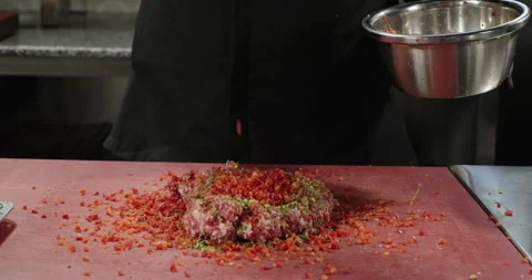 Chef adds chopped red bell pepper to ground meat with pistachios. Professional Stock Footage 274677119