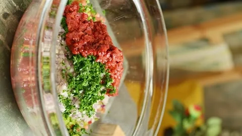 The chef adds chopped roasted red peppers to the ingredients for Ezme. Vidéo 333708337