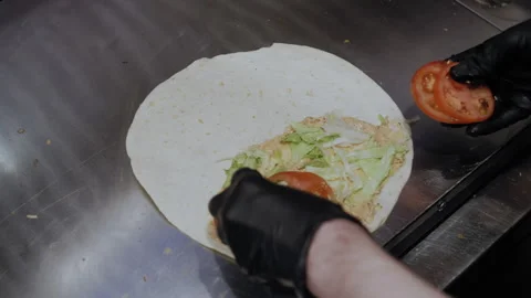 Chef Adds Chopped Tomatoes to Lavash with Sauce and Green Stockbeeldmateriaal 307058892